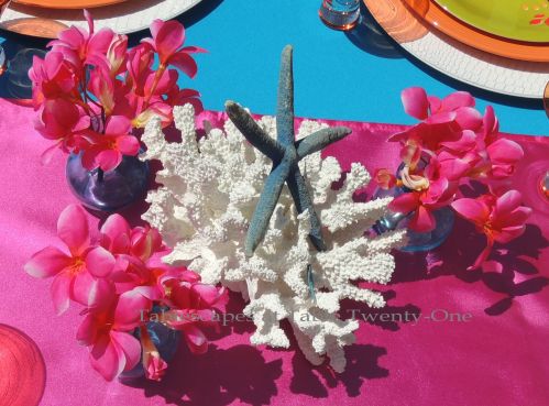 Tablescapes at Table Twenty-One:Budget-friendly tropical centerpiece using white coral, dyed blue starfish with bright pink plumeria