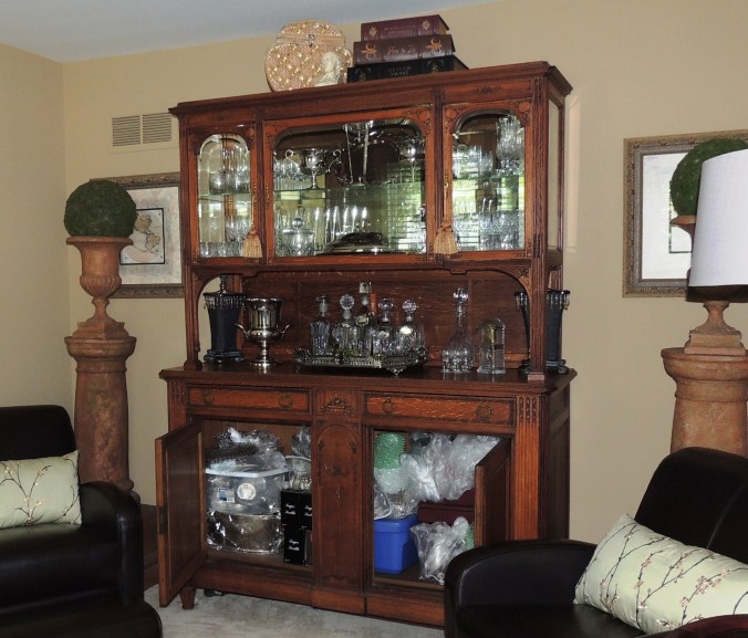 This Louis XIV reproduction vitrine is filled with silver, crystal, and six velvet-lined boxes of flatware.
