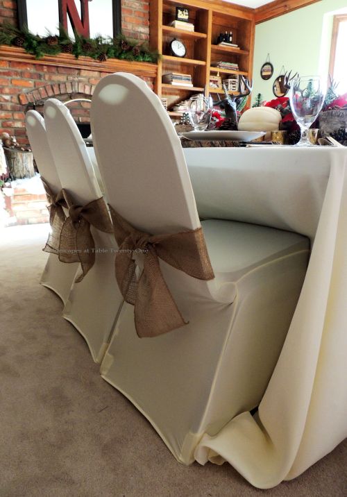 Alycia Nichols, Tablescapes at Table Twenty-One, www.tabletwentyone.wordpress.com, ”Over the River & Through the Woods – Transitional Tablescape: Banquet chairs dressed in LinenTablecloth.com stretch ivory chair covers and burlap sashes